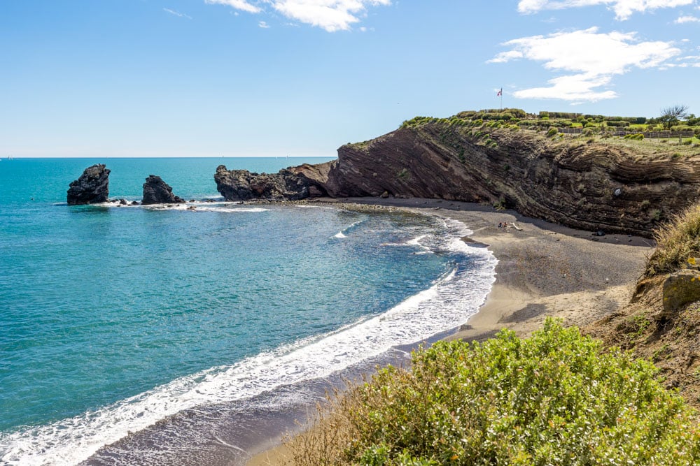 Schwarzer Sandstrand und Vulkanklippen in Cap d'Agde